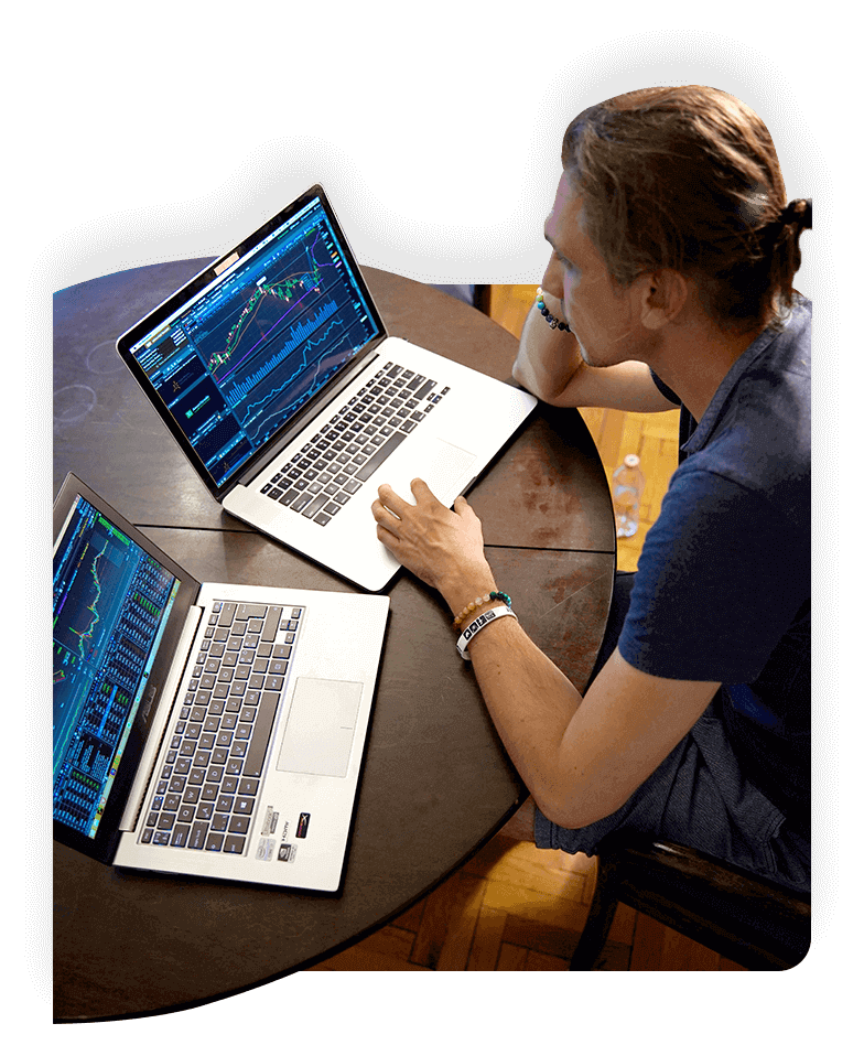Man working with two laptops looking at important data sets.